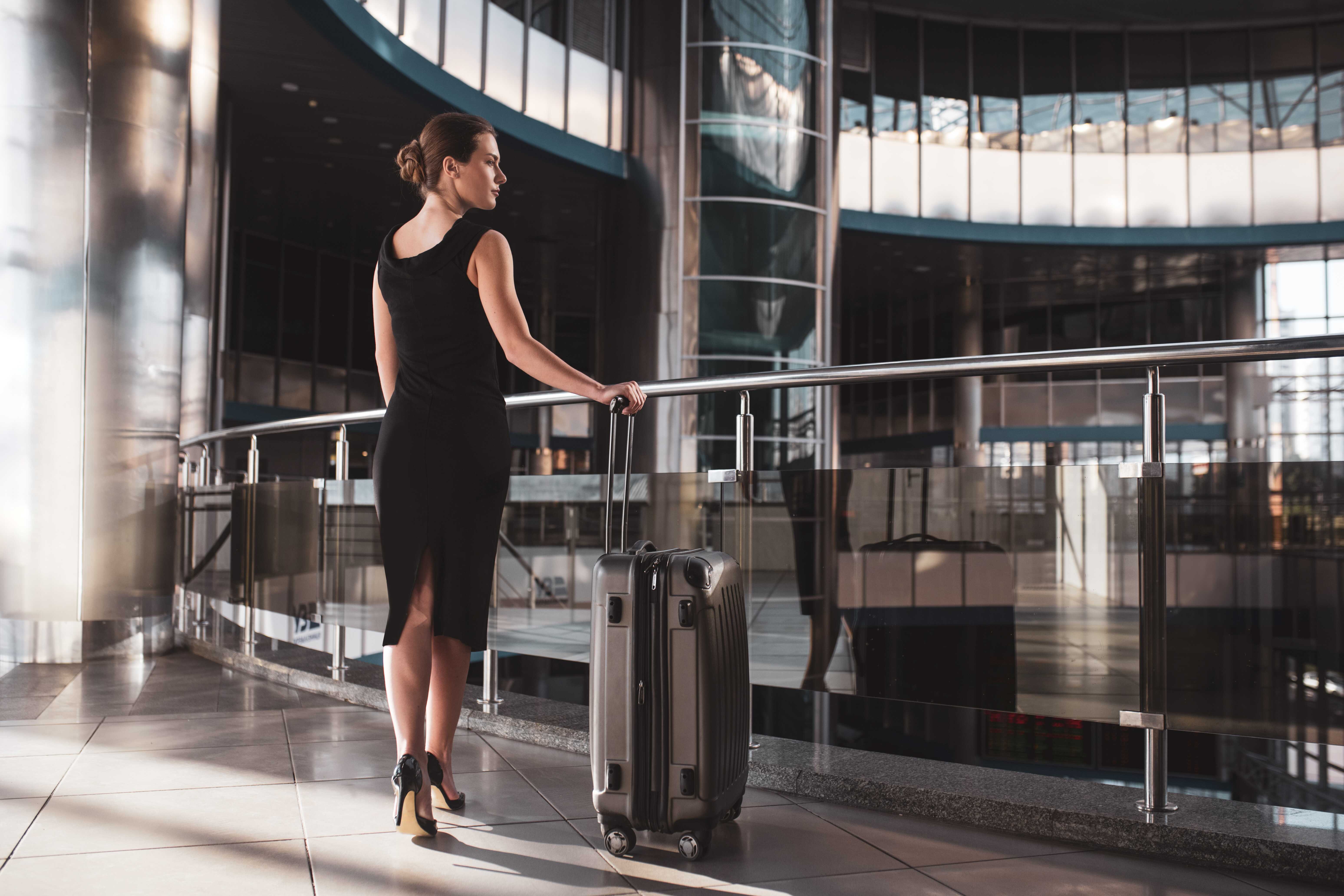 Woman standing at the entrance of a private VIP airport terminal before boarding a charter flight.